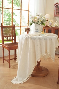 Detailed view of beige tablecloth fabric texture with soft decorative fringe tassels