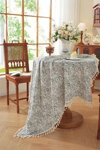Détail de nappe jacquard bleue à motifs géométriques avec pompons blancs artisanaux