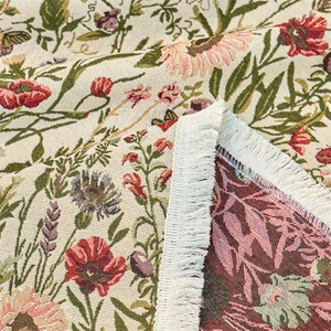 Close-up of woven floral jacquard tablecloth with red poppies and white tassels