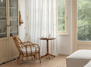Detail of white polyester curtain with black geometric stripes and fringe trimming