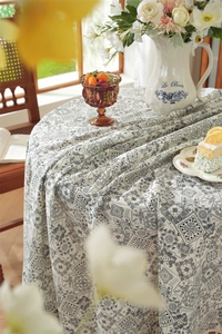 Détail des motifs floraux paisley bleus sur une nappe en coton pour tables rondes