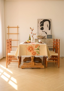 Detail of vintage floral tablecloth with orange daisies and white fringe edges