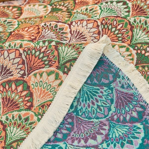 Close-up of double-sided jacquard weave with floral patterns and white fringe tassels