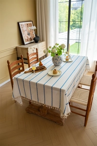 Detailed view of striped polyester tablecloth with elegant fringe trim and woven texture