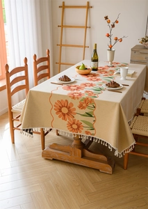 Close-up of floral jacquard tablecloth with yellow sunflower patterns and white fringe