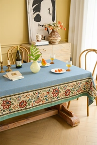 Detail of floral embroidery on the edge of a gray-blue rustic table runner and fabric