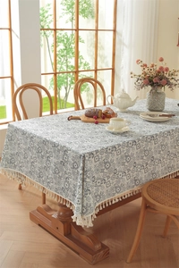 Détail de nappe en coton à fleurs bleues avec des glands blancs et des motifs géométriques