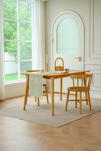 Detailed view of light green jacquard table runner with white embroidery and tassels