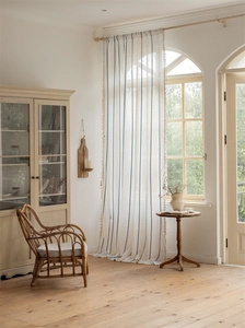 Detail of semi-transparent polyester curtain with blue geometric stripes and fringe