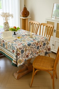 Vintage floral jacquard tablecloth on a rustic wooden dining table in a cozy home