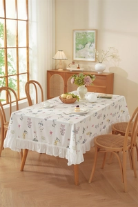 Detailed close-up of floral print cotton tablecloth with elegant ruffled edge design
