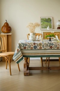 Close-up of vintage floral jacquard tablecloth with ethnic geometric fringe detail