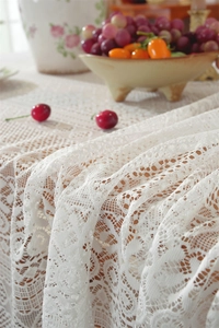 Detailed view of intricate white floral lace patterns with delicate hollow-out embroidery