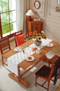 Close-up of plush white Halloween table runner with black ghost embroidery on table