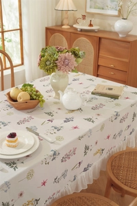 Close-up of cotton floral tablecloth featuring elegant ruffled edges and botanical prints