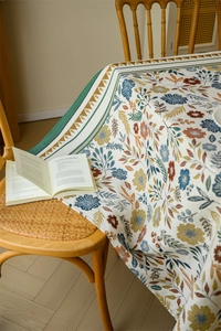 Detailed shot of retro floral jacquard tablecloth with woven texture and green serrated edges