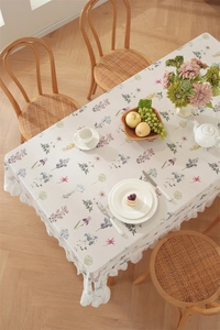 Detail of floral cotton tablecloth showing delicate frill edges and botanical prints