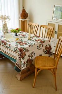 Close-up of vintage floral jacquard tablecloth with elegant green stitched border