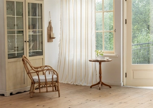 Detailed close-up of white semi-sheer curtains with gold chain embroidery and beige pompom trim