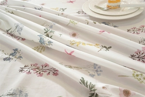 Close-up of cotton floral tablecloth with ruffled edges and elegant leaf patterns