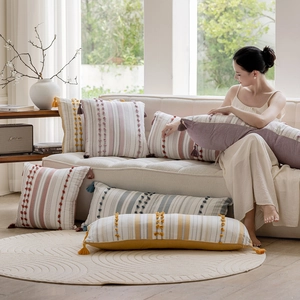 Detail of Nordic cotton pillow covers featuring textured tufted stripes and tassels
