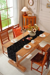 Halloween table runner with black ghost embroidery and orange decorative plush pillows
