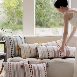 Detail of Nordic boho cushion cover with textured tufting stripes and tassel accents