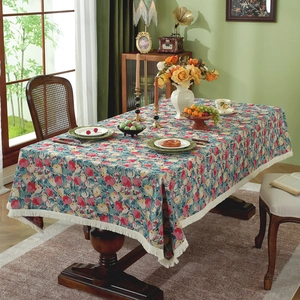 Vintage floral jacquard tablecloth with fringe tassels on a rustic wooden dining table