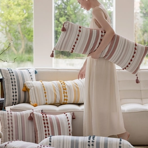 Close-up of bohemian style cotton pillow cover with textured pom-poms and tassels