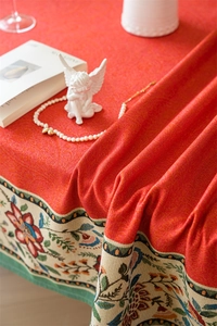 Close-up of red jacquard tablecloth with vintage floral woven border and thick texture