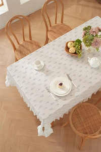 Close-up of cotton floral tablecloth featuring elegant ruffled edges and leaf patterns
