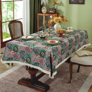 Retro geometric jacquard tablecloth with tassels on a rustic wooden dining table