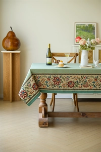 Detail of floral embroidery on vintage green jacquard tablecloth for dining tables