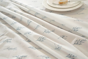 Close-up of cotton floral tablecloth showing delicate leaf prints and ruffle edge details
