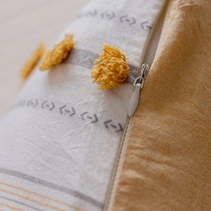 Detail of hidden zipper and yellow tufted texture on Nordic cotton lumbar pillow cover