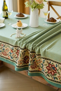 Detail of vintage green jacquard tablecloth with bohemian floral embroidery and thick drape