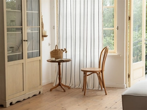 Close-up of cream geometric chain pattern curtain with delicate fringe tassel edges