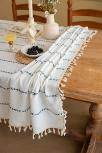 Detailed view of bohemian table runner with blue patterns and handmade beige tassels