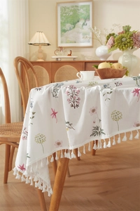 Detailed close-up of floral cotton tablecloth featuring elegant white tassel fringes