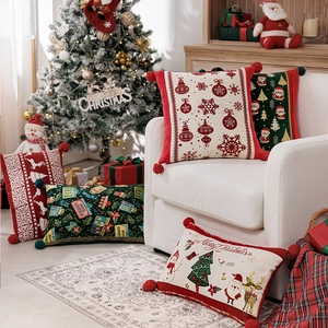 Dettaglio macro di federe natalizie in jacquard con pompon festivi e ricami eleganti