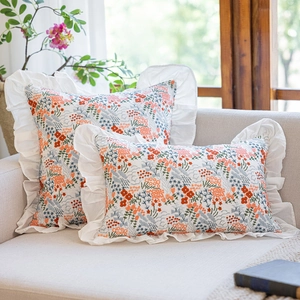 Detail of floral embroidery and elegant white ruffles on cotton cushion covers