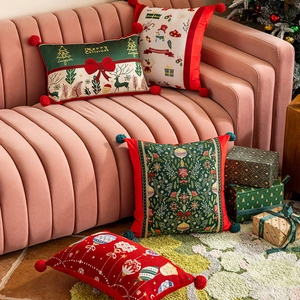 Federe natalizie festive con pompon e motivi decorativi su un divano