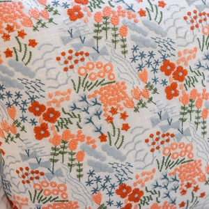 Detailed close-up of intricate floral embroidery and ruffles on a cotton pillowcase