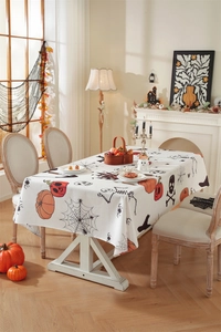 Macro detail of Halloween tablecloth with orange pumpkins and spider web motifs