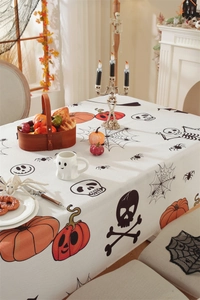 Close-up of textured Halloween tablecloth with pumpkin and skull prints in a festive setting
