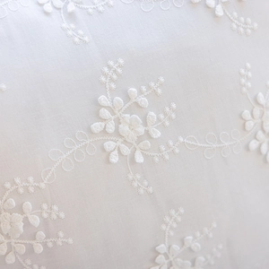 Detailed close-up of intricate white floral embroidery on premium cotton pillowcase