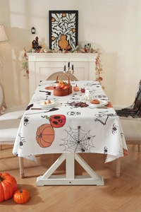 Detail of Halloween polyester tablecloth with pumpkin, bat and skull prints on a dining table