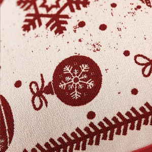 Vista macro della fodera per cuscino natalizio in maglia rossa e bianca con fiocchi di neve