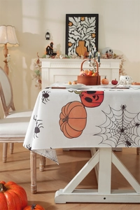 Detailed texture of Halloween tablecloth with pumpkins and spider webs on cream fabric