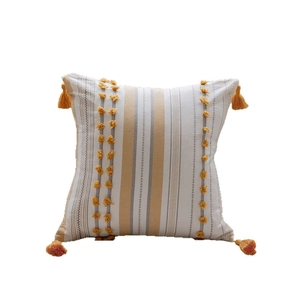 Boho square cotton pillow cover with mustard yellow tufting and tassels on white background